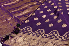 BKS129 Banarasi Mashru silk Saree in purple. Comes with gold zari work. Comes with stitched blouse size 38 can be altered to size 42. Fall peco done.