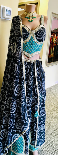 AFL9006 Bandhani printed lehenga in black. Comes with  stitched blouse and dupatta.