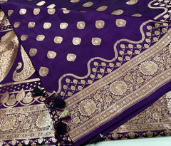 BKS129 Banarasi Mashru silk Saree in purple. Comes with gold zari work. Comes with stitched blouse size 38 can be altered to size 42. Fall peco done.