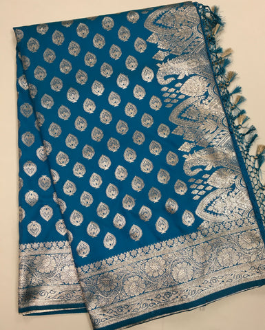 BKS124 Banarasi Mashru silk Saree in blue. Comes silver zari work. Comes with stitched blouse size 38 can be altered to size 42. Fall peco done.