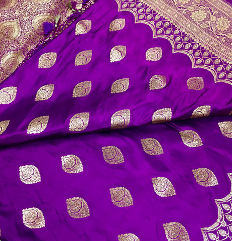 BKS115 Banarasi Mashru silk Saree in purple. Comes with gold zari work. Comes with stitched blouse size 38 can be altered to size 42. Fall peco done.
