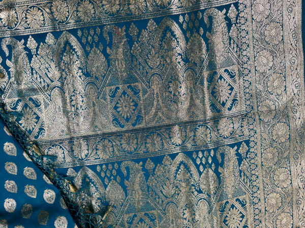 BKS124 Banarasi Mashru silk Saree in blue. Comes silver zari work. Comes with stitched blouse size 38 can be altered to size 42. Fall peco done.