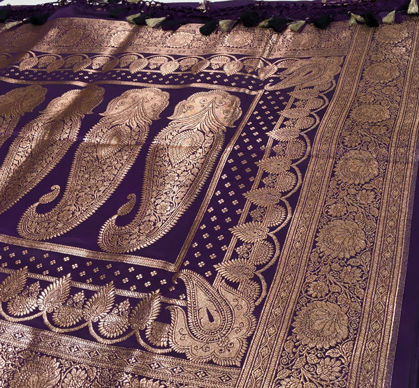 BKS129 Banarasi Mashru silk Saree in purple. Comes with gold zari work. Comes with stitched blouse size 38 can be altered to size 42. Fall peco done.