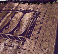 BKS129 Banarasi Mashru silk Saree in purple. Comes with gold zari work. Comes with stitched blouse size 38 can be altered to size 42. Fall peco done.
