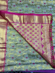 Semi Silk Saree in green with pink Gold zari border. Comes with stitched blouse size 38 can be altered up to 44