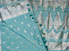 BKS118 Banarasi Mashru silk Saree in light blue. Comes with silver zari work. Comes with stitched blouse size 38 can be altered to size 42. Fall peco done.