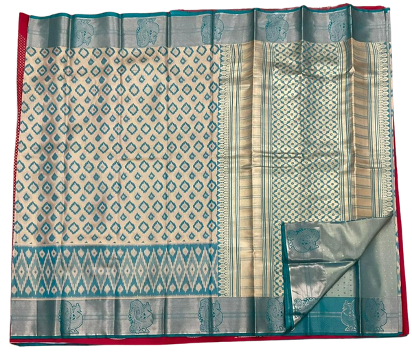HPSS604 - Banarasi Soft Silk Saree in Cream with Blue Patola design. Peacock Zari Butta on Border. Comes with stitched blouse (size 38, can go up to size 42). Fall Peco Done.
