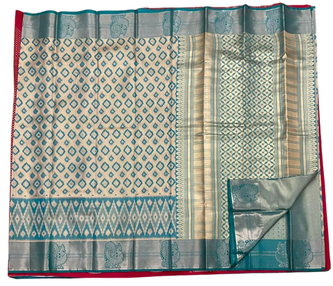 HPSS604 - Banarasi Soft Silk Saree in Cream with Blue Patola design. Peacock Zari Butta on Border. Comes with stitched blouse (size 38, can go up to size 42). Fall Peco Done.